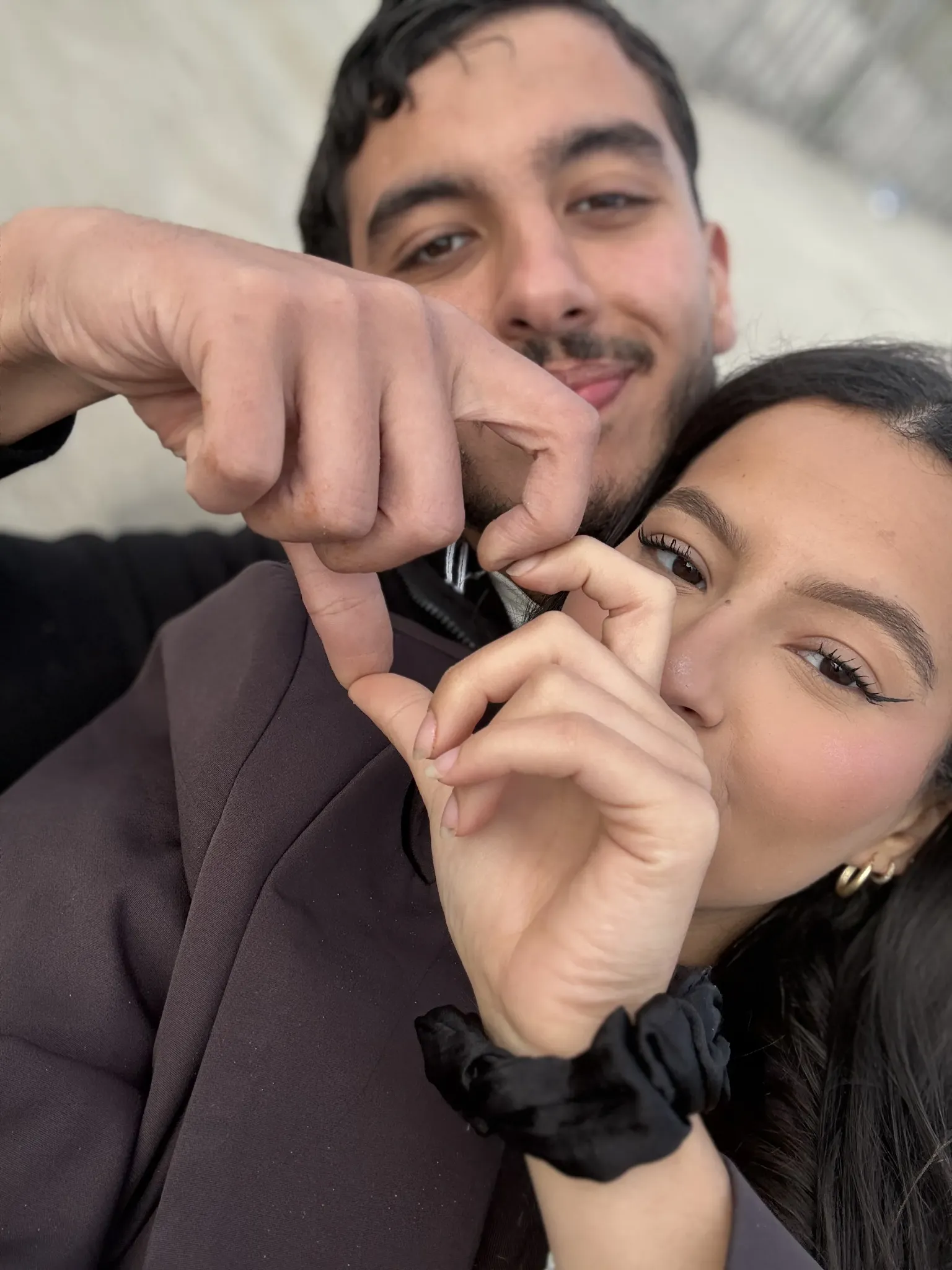 Manel et Driss formant un cœur avec leurs mains